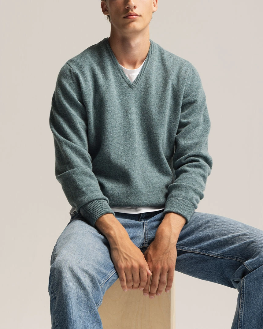 Groene trui met V-hals, gedragen met blauwe jeans